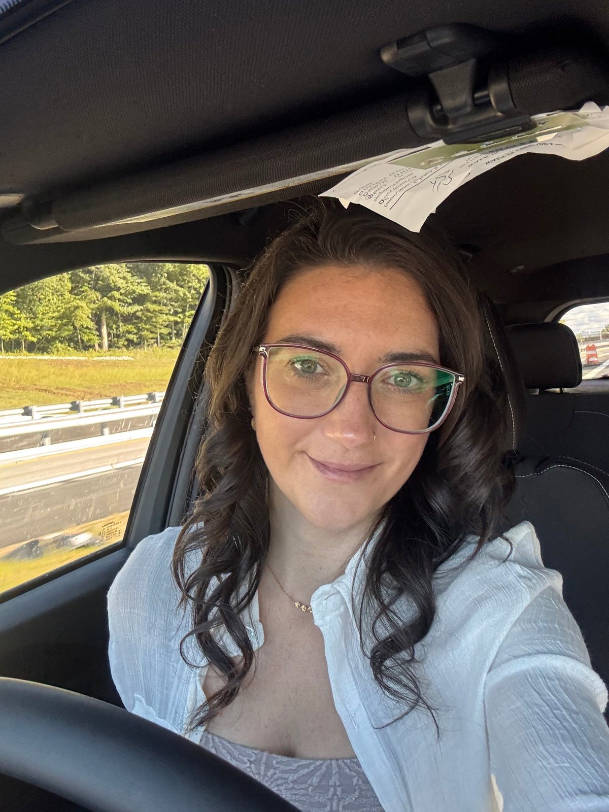 Sorta Chaos founder Ashley driving with reminders tucked into the car visor.